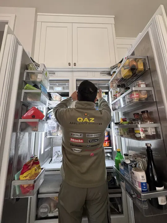 QAZ technician servicing a built-in refrigerator in a North Shore kitchen